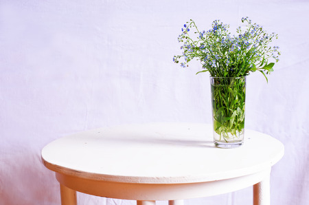 wild flowers in the glass on the white table. tinting. selective focusの写真素材