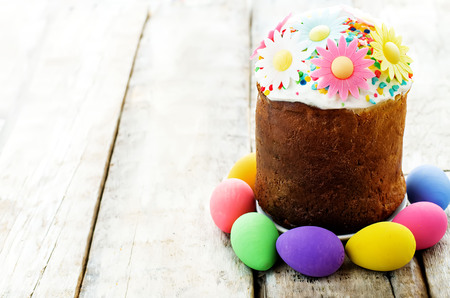 Easter cake with multicolored flowers on a white wood background. tinting. selective focusの写真素材
