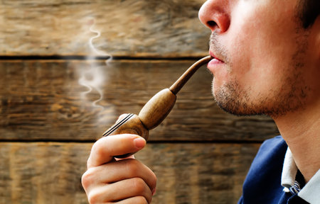 man smoking a pipe about wood walls. tinting. selective focus