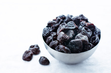 prunes in a bowl on a white background. tinting. selective focusの写真素材