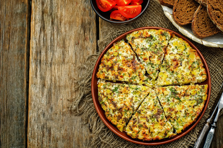 Frittata with chicken and potatoes on a dark wood background. tinting. selective focusの写真素材