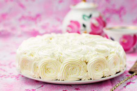 cake with vanilla cream in the form of roses on a pink background. tinting. selective focusの写真素材