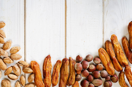 dried bananas with hazelnuts and almonds on white wood background. tinting. selective focusの写真素材