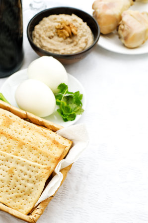 Matzah, wine, eggs, chicken, greens and haroset on a white background, traditional food for the...