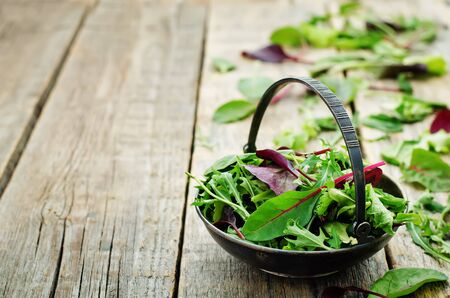 mix salad Romaine, arugula, spinach, mizuna, chard, oak salad on a dark wood background. tinting. selective focusの写真素材