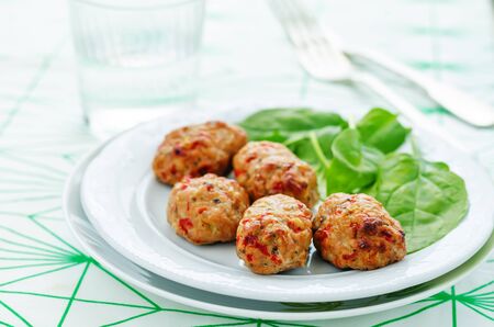 baked meatballs with pepper and spinach on a white background. tinting. selective focusの写真素材
