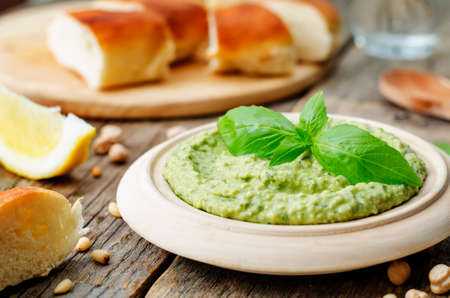 Basil pesto hummus on a dark wood backgroundの写真素材