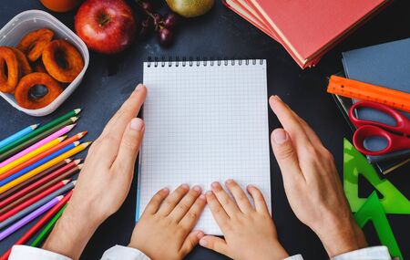 Man and child hands holding a notebookの写真素材