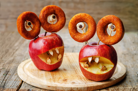apples, marshmallows and donuts in the shape of monsters for Halloween for kidsの写真素材