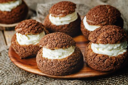 chocolate profiteroles, Shu, with cream on a dark wood background. the toning. selective focusの写真素材