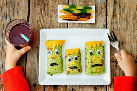 childrens hands with plate with lunch in the form of monsters for Halloween. the toning. selective focusの写真素材