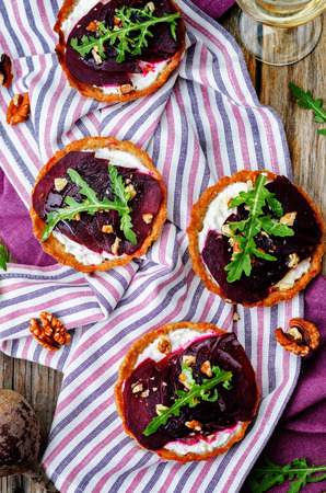 goat cheese beet arugula walnut honey tartlets on a dark wood background. toning. selective focusの写真素材
