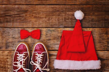wood background with sneakers red hood and a bow. toning. selective focusの写真素材