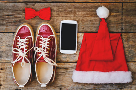 wood background with phone sneakers red hood and a bow. toning. selective focusの写真素材