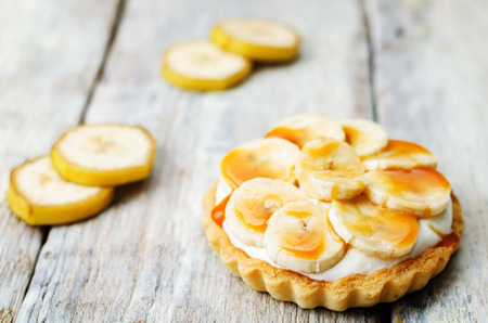 banana salted caramel tartlet on a white wood background. toning. selective Focusの写真素材