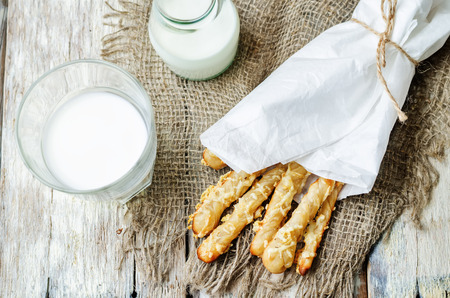 cheese bread sticks with milk on a white wood background. toning. selective Focusの写真素材