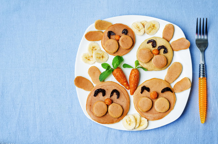 Pancake in the form of a rabbit and dried apricots cashew carrots for breakfast for children for Easter. toning. selective Focusの写真素材