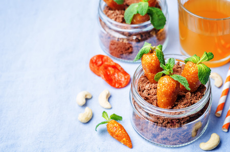 chocolate biscuit in a jar and dried apricots cashew candies in the form of carrots for children for Easter. toning. selective Focusの写真素材