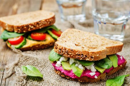 rye sandwiches with carrots and beetroot hummus and vegetables. toning. selective focusの写真素材