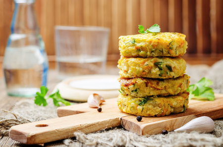 Cheesy millet zucchini fritters on dark wooden background. toning. selective focus