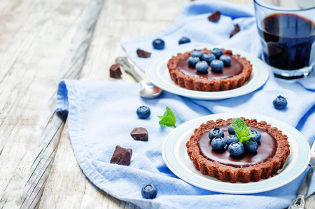 chocolate tartlets with chocolate filling and fresh blueberries. toning. selective focusの写真素材