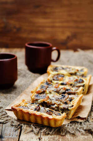mushroom onion quiche on a dark wooden background. toning. selective focusの写真素材