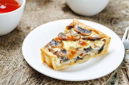 mushroom onion quiche on a white wooden background. toning. selective focusの写真素材