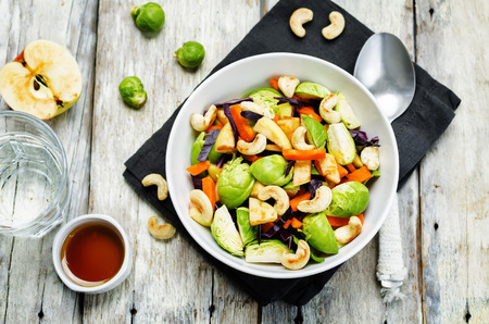 Brussels sprouts red cabbage carrot cashew apple salad with maple syrup, olive oil dressing. toning. selective focusの写真素材