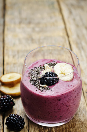 Blackberry oats banana smoothie on wood background. toning. selective focusの写真素材