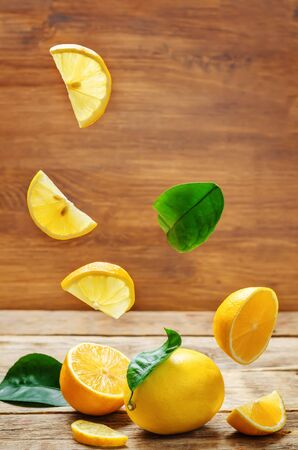 lemons with flying slices on a wood background. tinting. selective focusの写真素材