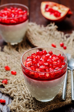 Pomegranate mousse in a glass on wood background. toning. selective focusの写真素材