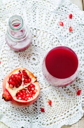 Pomegranate juice on a wood background. toning. selective focusの写真素材