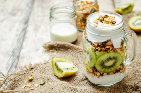 Greek yogurt granola kiwi breakfast in jar. toning. selective focusの写真素材