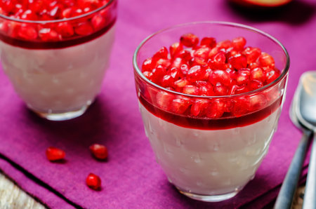 Pomegranate mousse in a glass on wood background. toning. selective focus