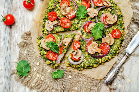 Kale oats pizza crust with tomato, red onion and mushrooms. toning. selective focusの写真素材