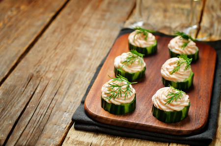 Cucumber salmon mousse appetizer on a wood background. toning. selective focusの写真素材