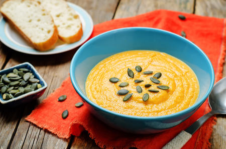 Sweet potato carrot soup on a wood background. toning. selective focusの写真素材