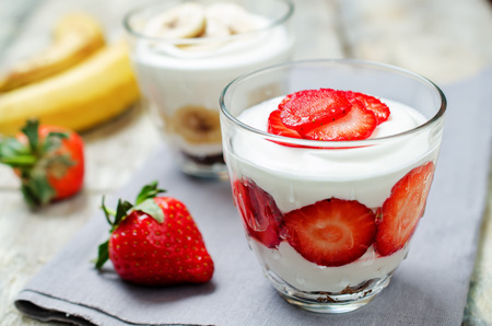 Greek yogurt strawberry and banana parfaits on a wood background. toning. selective focusの写真素材