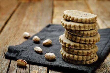 Cashew butter cookies with pistachios on a wood background. toning. selective focusの写真素材