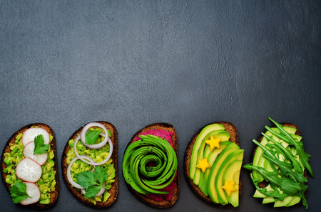 Variation of healthy rye breakfast sandwiches with avocado and toppings. toning. selective focusの写真素材