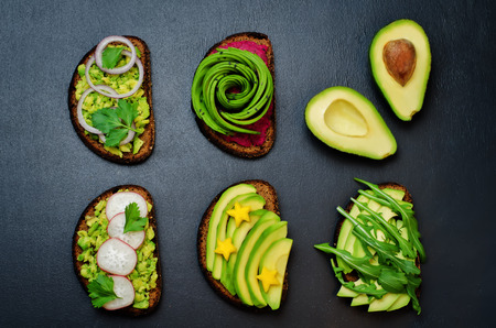 Variation of healthy rye breakfast sandwiches with avocado and toppings. toning. selective focusの写真素材