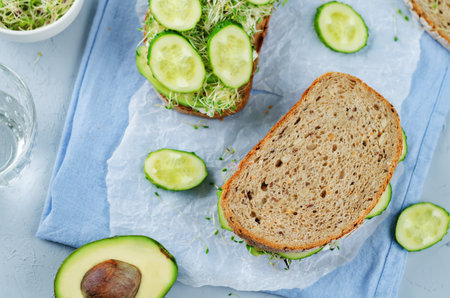 Ricotta sprouts avocado cucumber rye sandwich. toning. selective focus