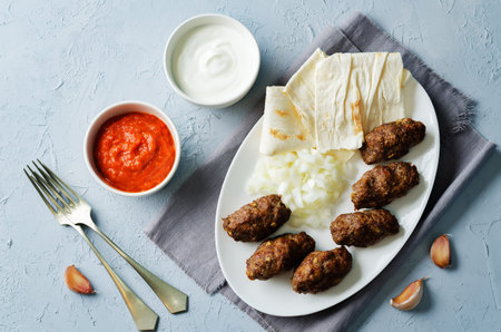 Minced meat sausage with onion, sour cream, pita and red bell pepper relish. Cevapi with Ajvar...
