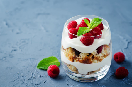 Greek yogurt raspberry biscuit parfait on a stone background. toning. selective focusの写真素材