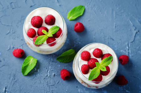 Greek yogurt raspberry biscuit parfait on a stone background. toning. selective focusの写真素材