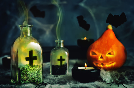 Halloween horror background with a spider's web, pumpkin; candles, potions and bats. Space for your holiday text on Halloween.の写真素材