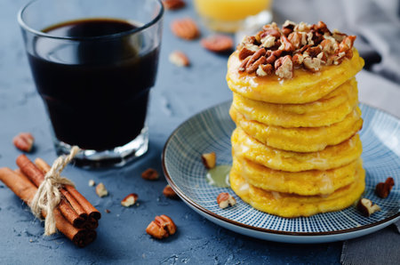 Pumpkin pancakes with pecans on a stone background. toning. selective focus