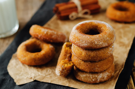 Baked pumpkin donuts with glasses of milk. toning. selective focusの写真素材