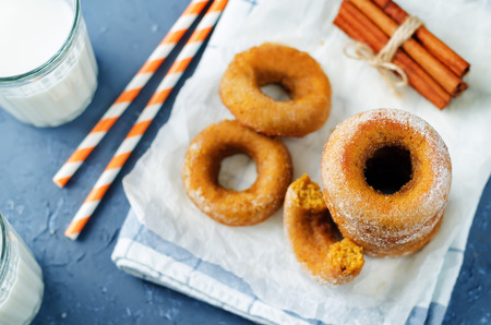 Baked pumpkin donuts with glasses of milk. toning. selective focusの写真素材