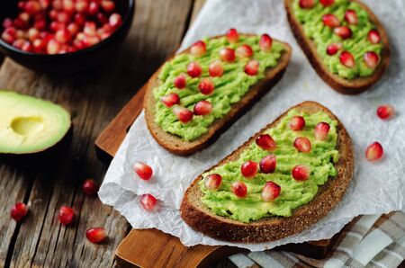 Smashed avocado pomegranate rye sandwiches. toning. selective focusの写真素材